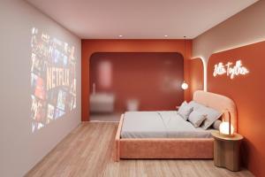 a bedroom with a bed with an orange wall at Sanora Hotel in Hanoi