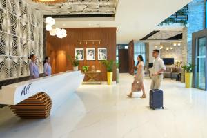 a group of people walking in a lobby with a suitcase at Adagio Premium The Palm in Dubai +149 photos