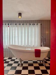 a bath tub in a bathroom with a checkered floor at STAY Standard HOTEL Kohlarn in Ko Larn