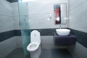 a bathroom with a toilet and a sink and a mirror at Shree Priyam Residency in Rāmanāthapuram +19 photos