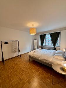 a bedroom with a large bed and a table at Basic Apartment in Witikon district in Zurich