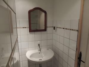 a white bathroom with a sink and a mirror at Gite Grand-Mère in Charron