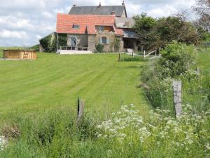 an old house in a field with a fence at Gite Grand-Mère in Charron +15 photos