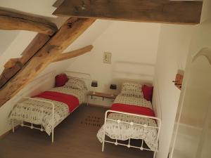 two beds in a attic room with wooden beams at Gite Grand-Mère in Charron