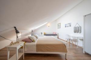 a white bedroom with a bed and a desk at Apartments TERRAeSAL in Zadar