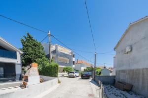 a street with a building and a car parked at Apartments TERRAeSAL in Zadar