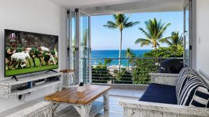 a living room with a tv and a view of the ocean at Chakas Cove in Ballito