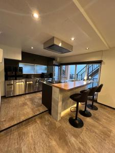 a kitchen with a counter and some chairs in it at VILLA VINO ATAMI m in Atami