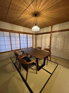 a dining room with a wooden table and chairs at VILLA VINO ATAMI m in Atami