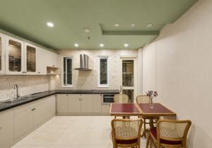 a large kitchen with a table and chairs at Elm Riverside Hotel by Urban B in Ho Chi Minh City