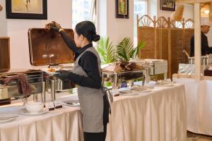 a woman standing in front of a table with food at Phnom Penh Katari Hotel in Phnom Penh +130 photos
