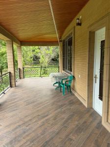 a porch with two green benches on a house at House in Katex