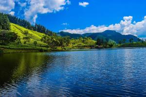 a view of a lake with mountains in the background at The Wood Cottage in Elkaduwa