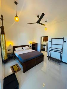 a bedroom with a bed and a ceiling fan at Sasaa Guest House in Mirissa