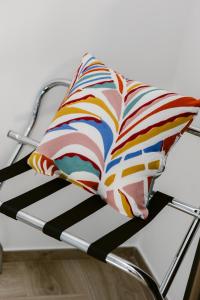 a colorful pillow sitting on a metal bed at Erigia House - Appartamenti Eleganti - Molfetta in Molfetta