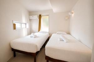 two beds in a small room with white walls at Balmy Ocean OKINAWA in Yomitan