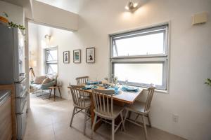 a kitchen and dining room with a table and chairs at Balmy Ocean OKINAWA in Yomitan