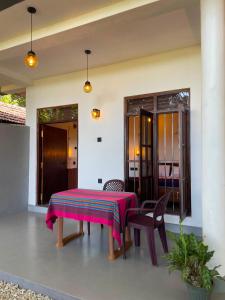 a table and chairs on the patio of a house at Sasaa Guest House in Mirissa