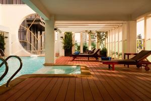 a pool in a hotel with chairs and a table at Phnom Penh Katari Hotel in Phnom Penh