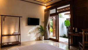 a bedroom with a bed and a tv on a wall at Villa Kebun Pala in Borobudur