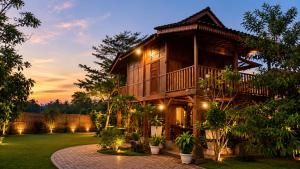 a wooden house with a courtyard in front of it at Villa Kebun Pala in Borobudur