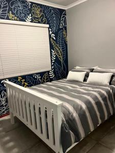 a bedroom with a bed and a blue and white wall at Flamingo Park D1 Langebaan in Langebaan