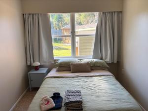 a bed in a room with a large window at Cute Chartwell Cottage in Hamilton