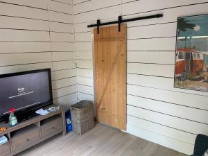 a door in the corner of a room with a television at La Cabane des P’tits chiffon in Lacanau