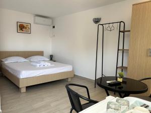 a bedroom with a bed and a table with chairs at Vila Elna in 2 Mai