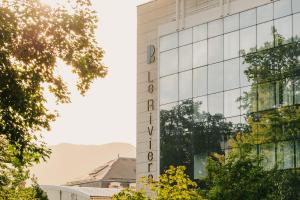 a building with a sign on the side of it at Le Riviera - Hôtel Restaurant & Spa - Ex Golden Tulip Aix les bains in Aix-les-Bains
