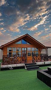 a large wooden building with windows on the grass at شاليه دار وارف in As Sayl aş Şaghīr