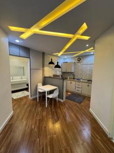 a room with a table and a kitchen with yellow ceilings at شاليه دار وارف in As Sayl aş Şaghīr