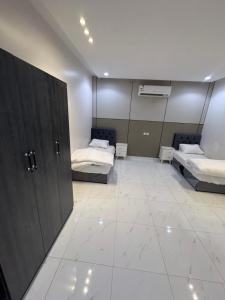 a room with two beds and a large mirror at شاليه دار وارف in As Sayl aş Şaghīr