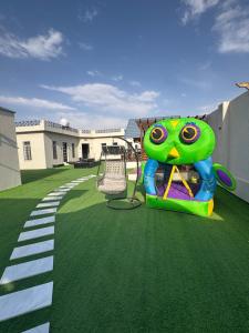 a playground with a green frog on the grass at شاليه دار وارف in As Sayl aş Şaghīr