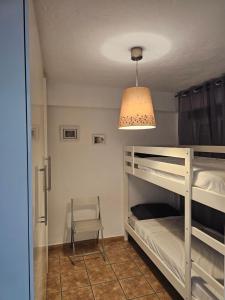 a bedroom with a bunk bed with a lamp and a chair at Sea View & Beach View Appartement Torre Del Mar in Torre del Mar +6 photos