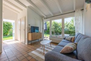 a living room with a blue couch and a tv at Nordisch Nest in Bistensee