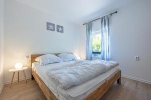 a bedroom with a large bed with a window at Nordisch Nest in Bistensee