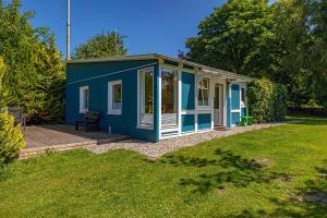 a blue and white shed in a yard at Nordisch Nest in Bistensee