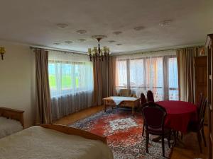 a bedroom with a red table and chairs and a dining room at Pokoje u Janeczki in Jałowo +19 photos