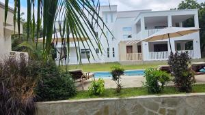 a villa with a swimming pool and a house at SaltSunRetreat Villa in Ukunda