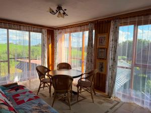 a dining room with a table and chairs and a balcony at Pokoje u Janeczki in Jałowo