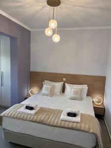a bedroom with a large bed with two towels on it at AMORÉA Jacuzzi Suites Evia in Eretria +107 photos