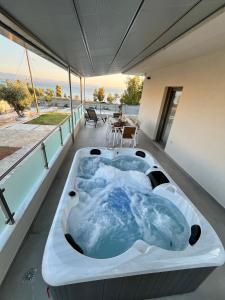 a hot tub on the balcony of a house at AMORÉA Jacuzzi Suites Evia in Eretria