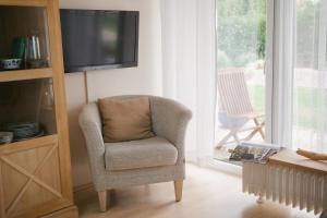 a living room with a chair and a television at Haus Isabel in Büsum