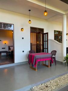 a room with a table with a pink blanket on it at Sasaa Guest House in Mirissa