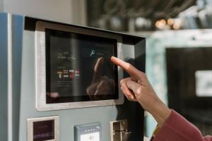 a person is pointing at a machine with their hand at Hotel Das Lola in Essen