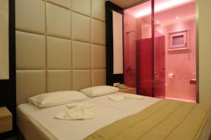a bedroom with a bed and a glass shower at Louloudis Fresh-Adults Only in Skala Rachoniou