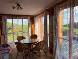 a room with a table and chairs and a large window at Pokoje u Janeczki in Jałowo
