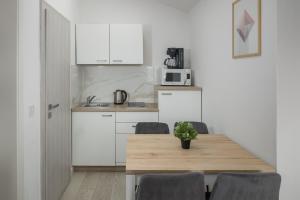 a kitchen with a table and chairs and a microwave at Apartment Complex Vetrina-Shared Pool in Nova Vas