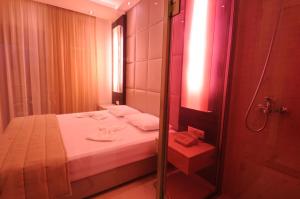 a small bathroom with a bed and a shower at Louloudis Fresh-Adults Only in Skala Rachoniou